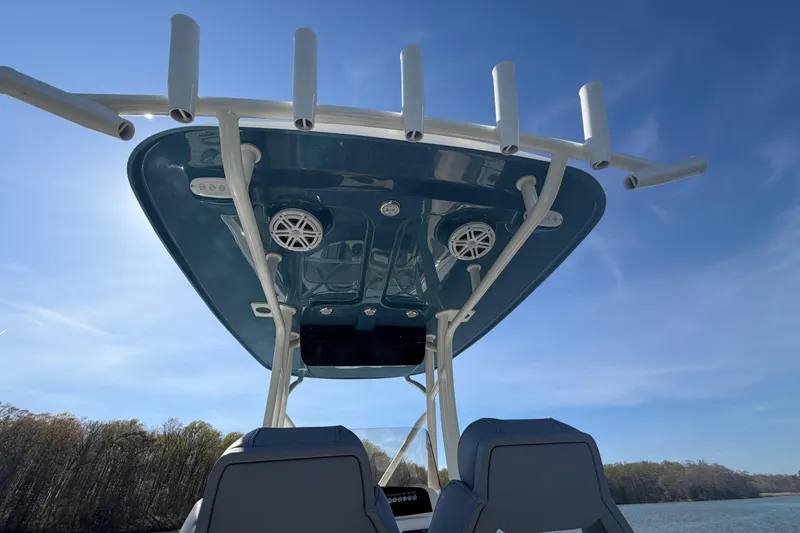 Slide: The Image of 2026 Pioneer 222 Islander boat with T-top and rod holders under clear blue sky. - 16