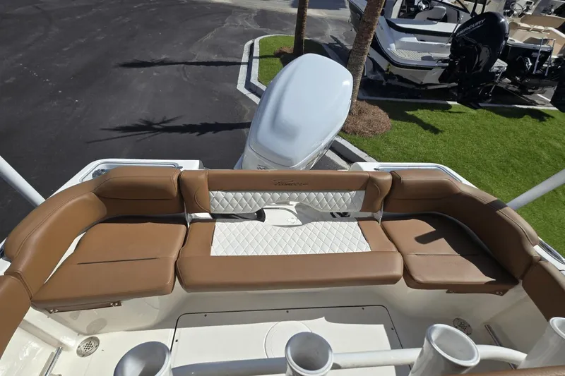 Slide: The Image of 2026 Pioneer 222 Islander boat with tan seating and white accents, docked outdoors. - 3
