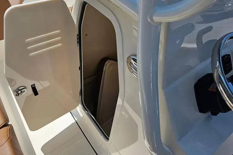 Slide: The Image of 2026 Pioneer 222 Islander boat console with open storage compartment and steering wheel. - 8