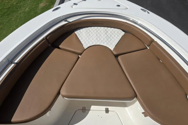 Slide: The Image of 2026 Pioneer 222 Islander boat with brown cushioned seating and white quilted accents. - 9