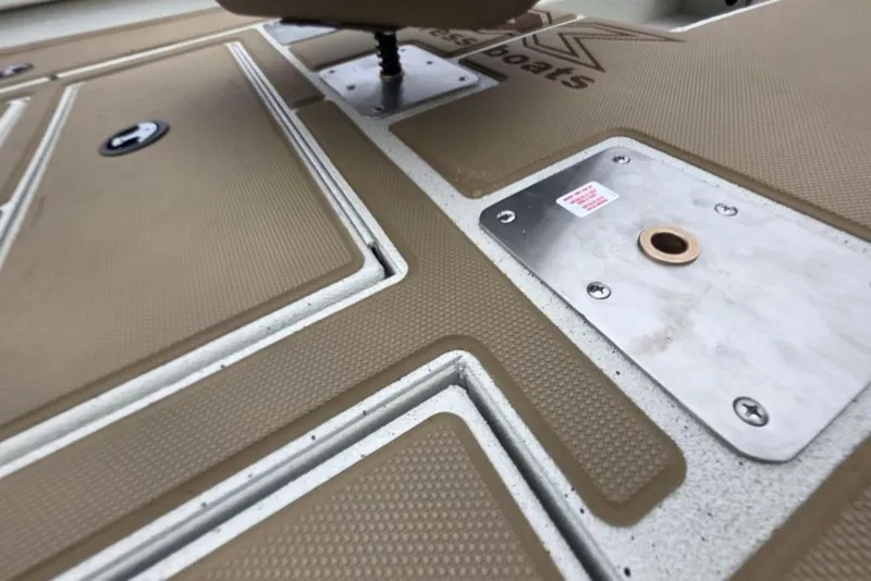 Slide: The Image of Deck of 2026 Xpress H18C Crappie boat with textured surface and metal fittings. - 13