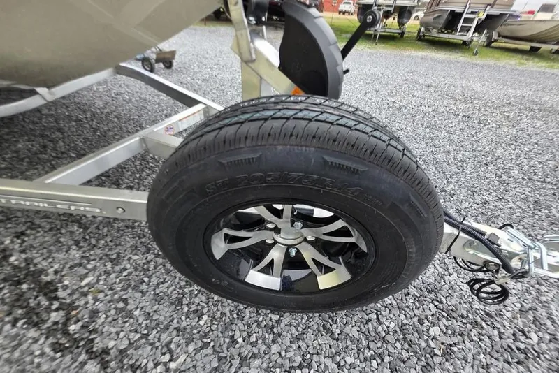 Slide: The Image of Trailer wheel of 2026 Xpress H18C Crappie boat on gravel surface. - 19