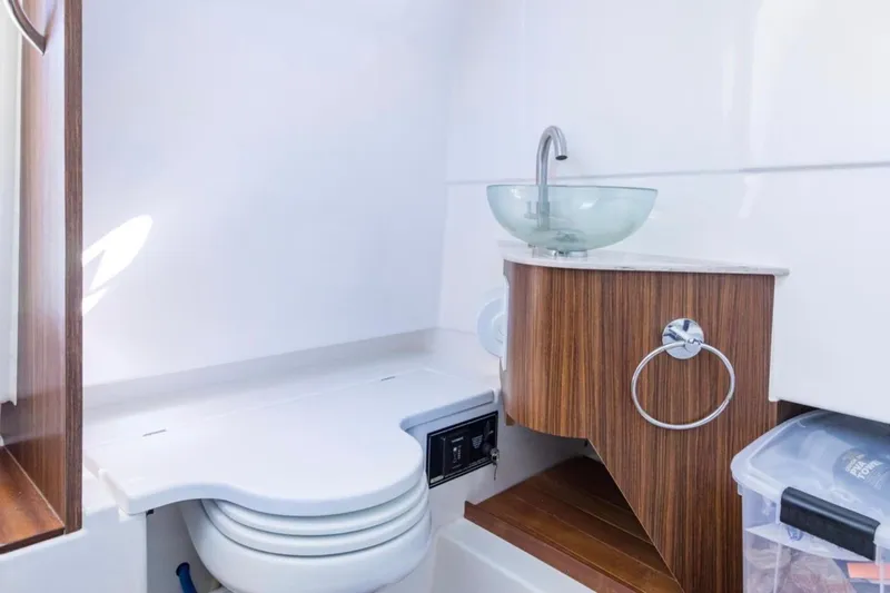 Slide: The Image of 2023 Pursuit S 328 Sport boat bathroom with modern sink and wooden accents. - 10