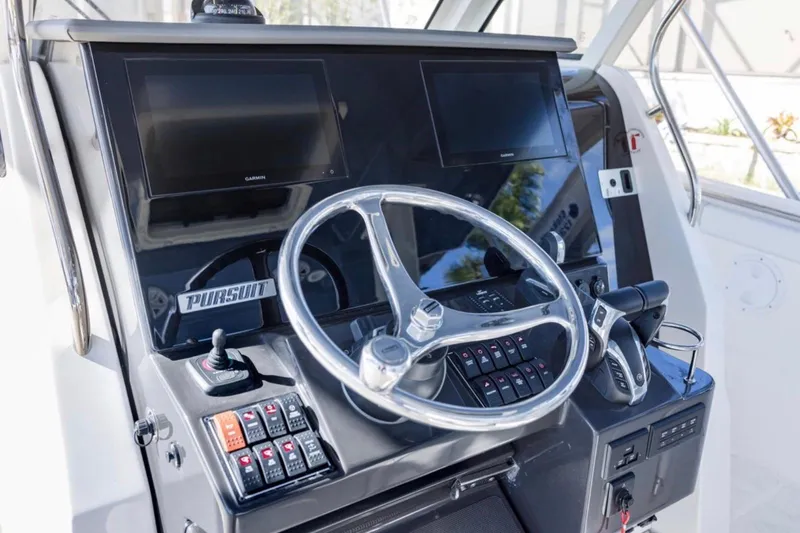 Slide: The Image of 2023 Pursuit S 328 Sport boat dashboard with dual screens and steering wheel. - 11
