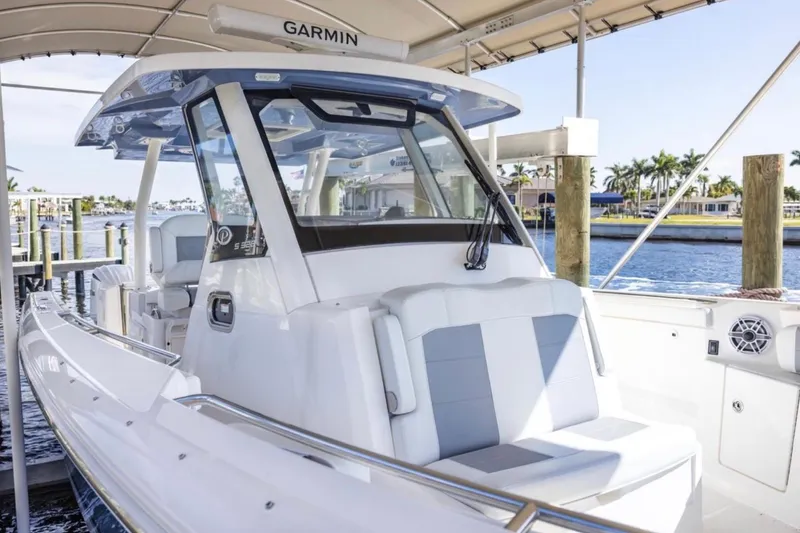 Slide: The Image of 2023 Pursuit S 328 Sport boat docked, featuring sleek design and modern amenities. - 12