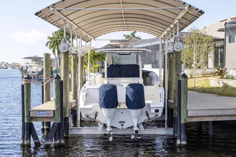 Slide: The Image of 2023 Pursuit S 328 Sport boat docked under canopy on waterfront. - 4