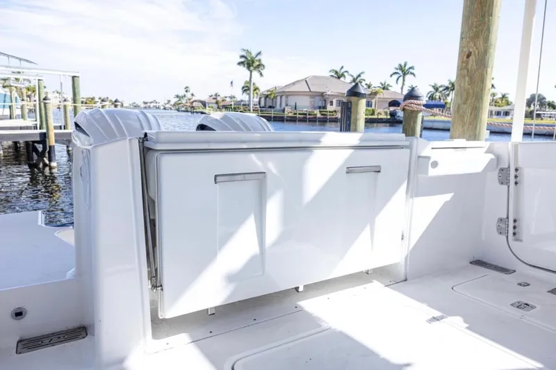 Slide: The Image of 2023 Pursuit S 328 Sport boat docked, showcasing sleek design and spacious deck area. - 5