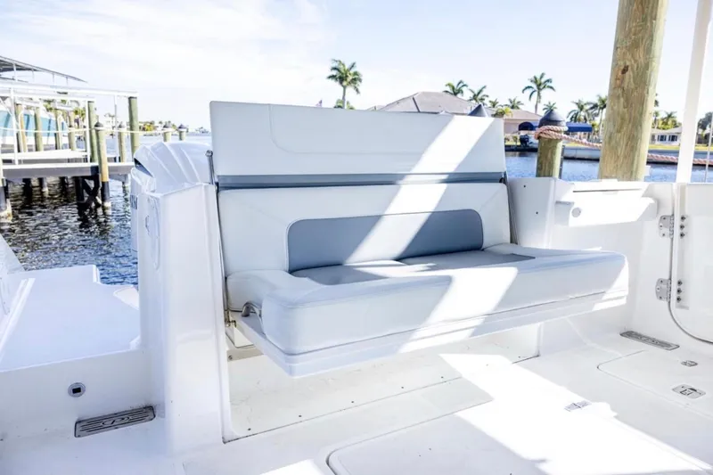 Slide: The Image of 2023 Pursuit S 328 Sport boat interior with cushioned seating by the water. - 6