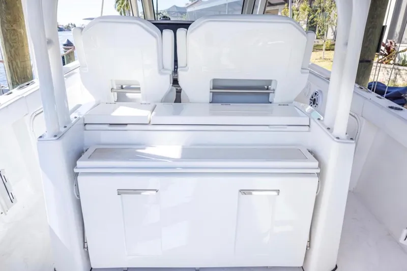 Slide: The Image of 2023 Pursuit S 328 Sport boat interior with sleek white seating and storage. - 7