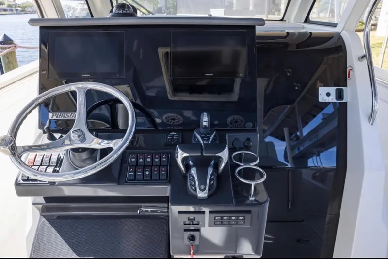Slide: The Image of 2023 Pursuit S 328 Sport boat dashboard with steering wheel and controls. - 9