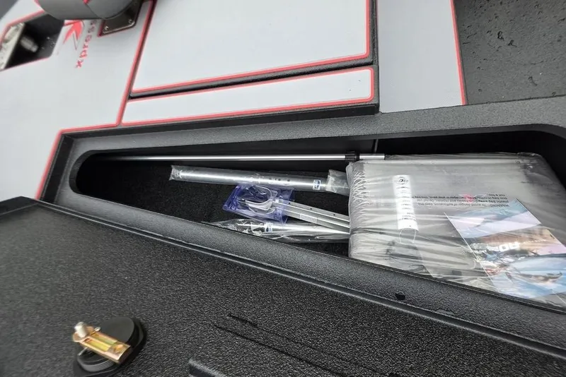 Slide: The Image of Storage compartment in 2026 Xpress H17 boat, containing manuals and accessories. - 15