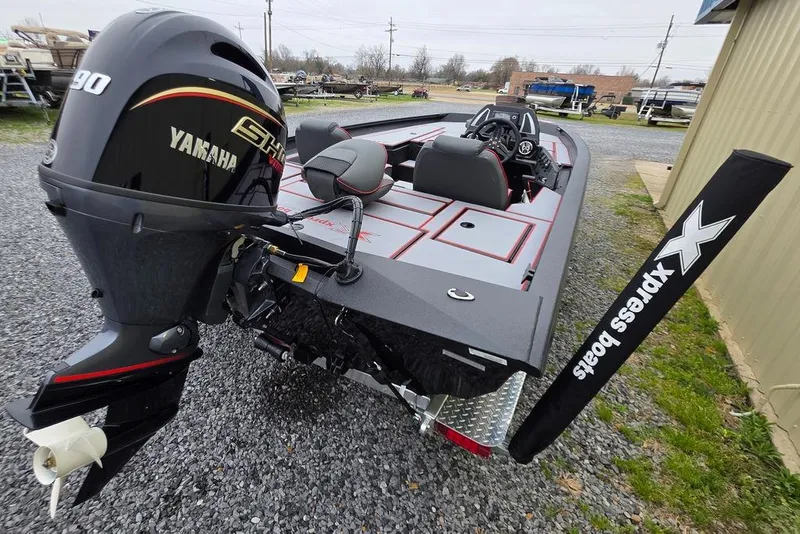 Slide: The Image of 2026 Xpress H17 boat with Yamaha engine, parked on gravel near a building. - 7