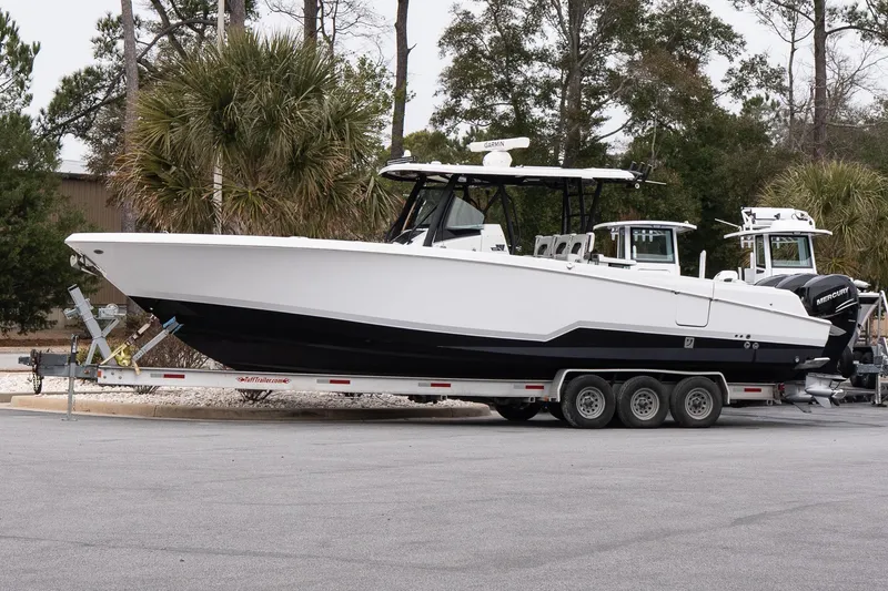 The Image of 2023 Wellcraft 352 Fisherman boat on trailer, parked outdoors with trees in background. - 1