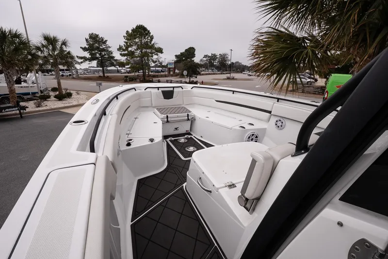 Slide: The Image of 2023 Wellcraft 352 Fisherman boat interior with seating and storage, docked near palm trees. - 21