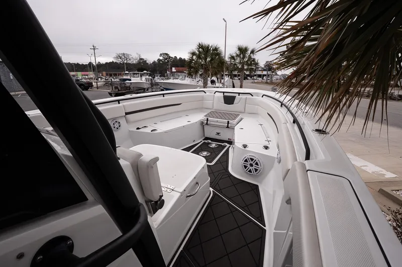 Slide: The Image of 2023 Wellcraft 352 Fisherman boat interior with seating and speakers, docked near palm trees. - 22