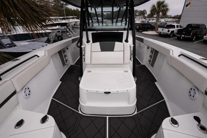 Slide: The Image of 2023 Wellcraft 352 Fisherman boat interior with seating and storage, docked at a marina. - 24