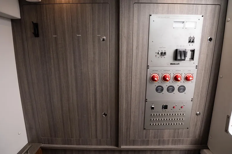 Slide: The Image of 2023 Wellcraft 352 Fisherman control panel with switches and dials on wood paneling. - 34