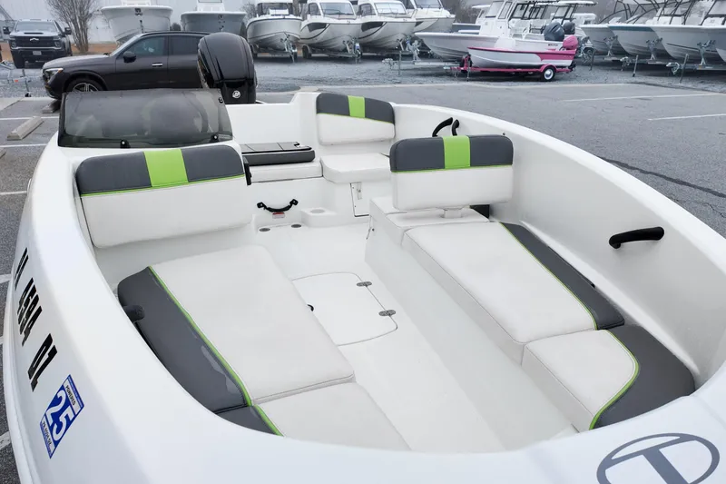 Slide: The Image of 2021 Tahoe T16 boat interior with gray and green seating in a marina. - 15