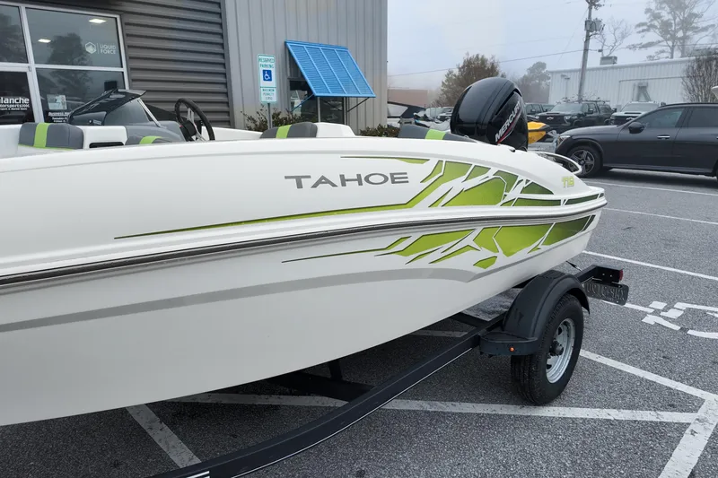 Slide: The Image of 2021 Tahoe T16 boat with green accents on a trailer in a parking lot. - 4