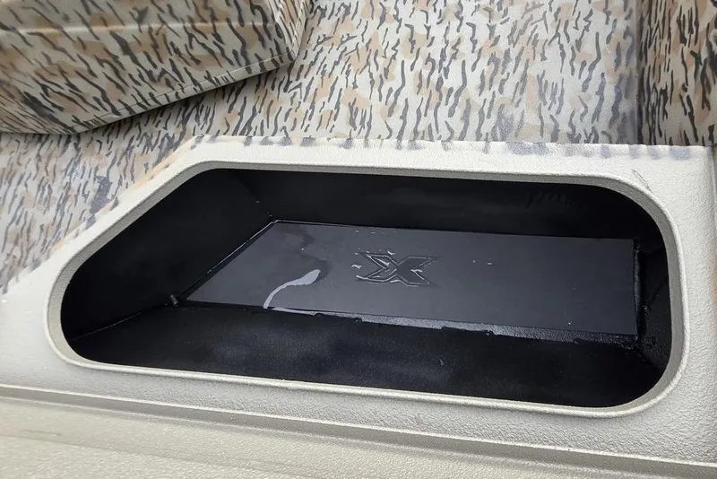 Slide: The Image of 2026 Xpress H20B Bay boat interior with camo pattern and storage compartment. - 17