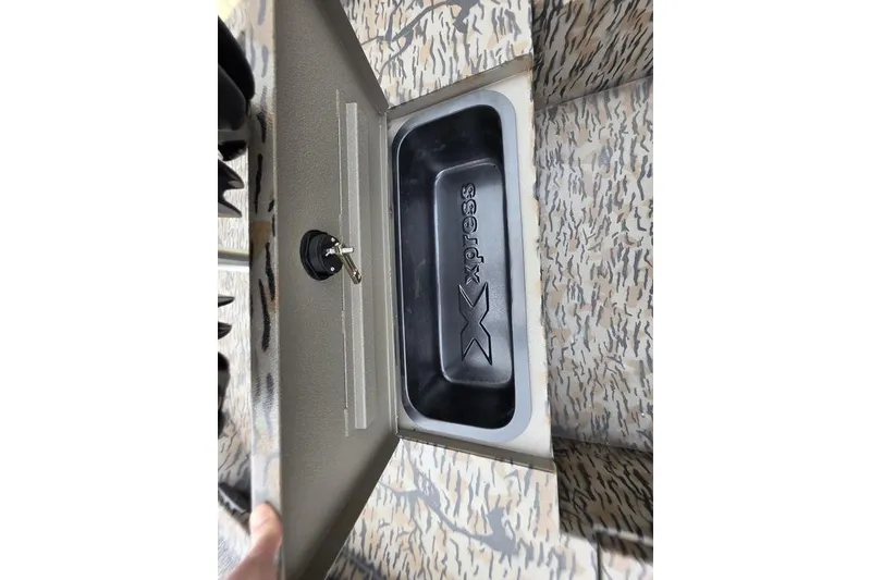 Slide: The Image of 2026 Xpress H20B Bay boat compartment with key, featuring camo design. - 23