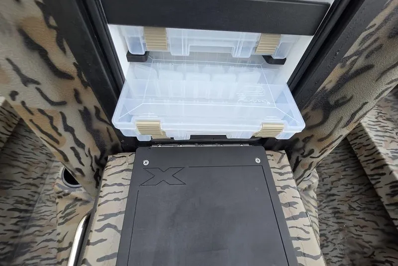 Slide: The Image of 2026 Xpress H20B Bay boat interior with camo seats and storage compartment. - 25