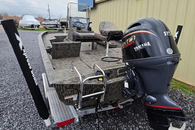 Slide: The Image of 2026 Xpress H20B Bay boat with Yamaha 115 engine, parked on gravel. - 4