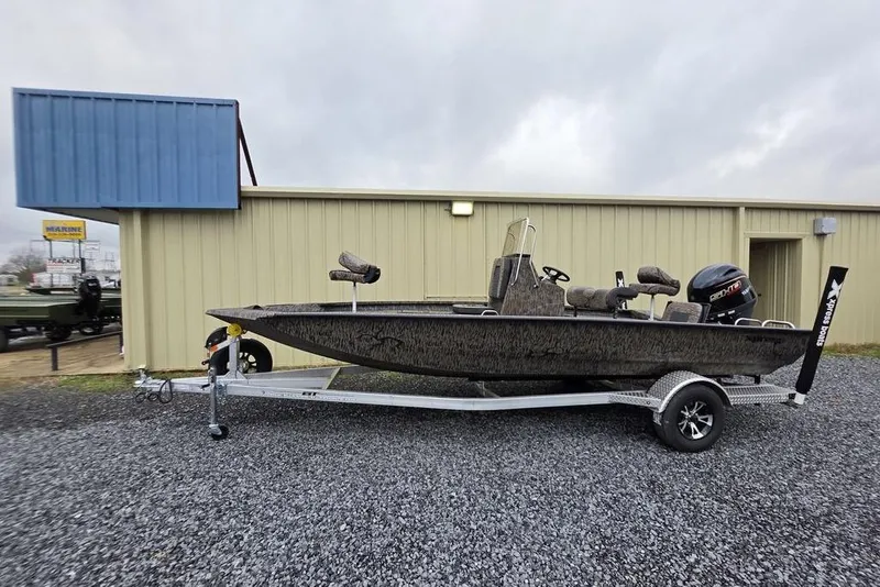 Slide: The Image of 2026 Xpress H20B Bay boat on trailer outside a beige building. - 5