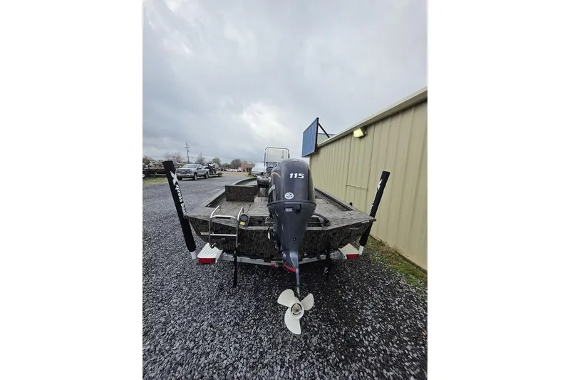 Slide: The Image of 2026 Xpress H20B Bay boat with 115 horsepower engine, parked on gravel. - 6