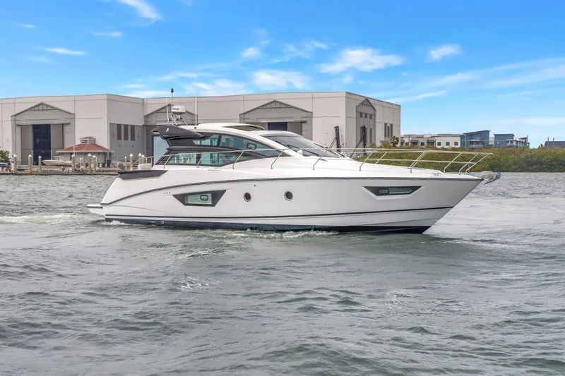 Slide: The Image of 2019 Beneteau Gran Turismo 46 yacht cruising on a calm waterway near industrial buildings. - 66