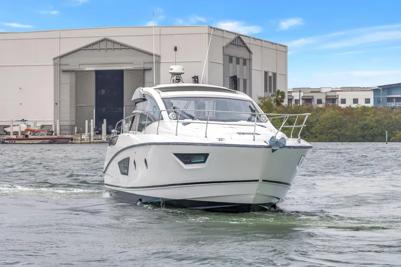 Slide: The Image of 2019 Beneteau Gran Turismo 46 yacht cruising near a marina with industrial buildings. - 71