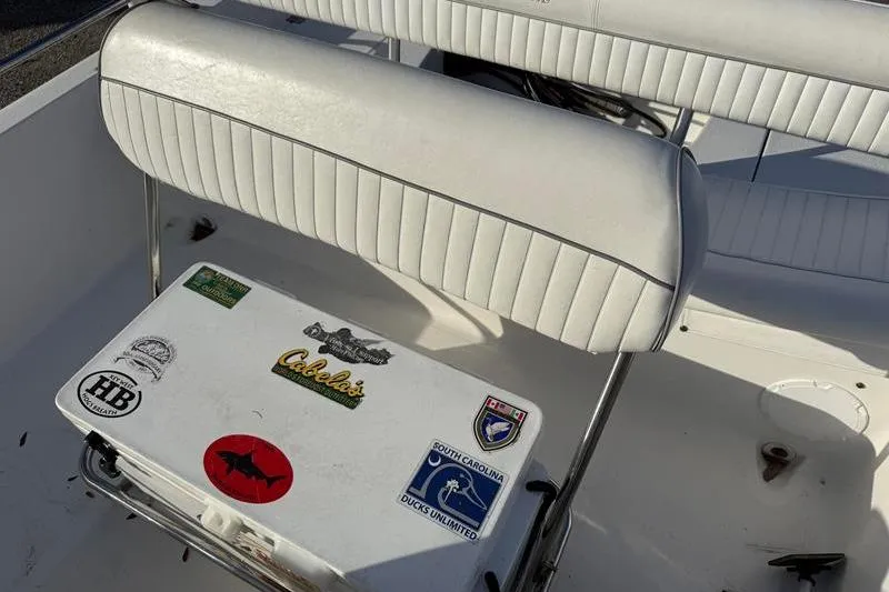 Slide: The Image of 2007 Sea Pro SV1900CC Bay Boat interior with white seating and sticker-covered cooler. - 13