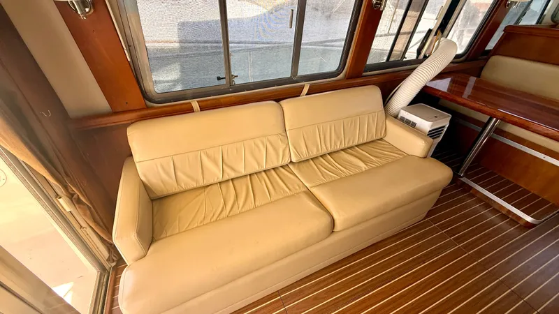 Slide: The Image of Interior of 2004 Mainship 400 Trawler with leather sofa and wood flooring. - 13