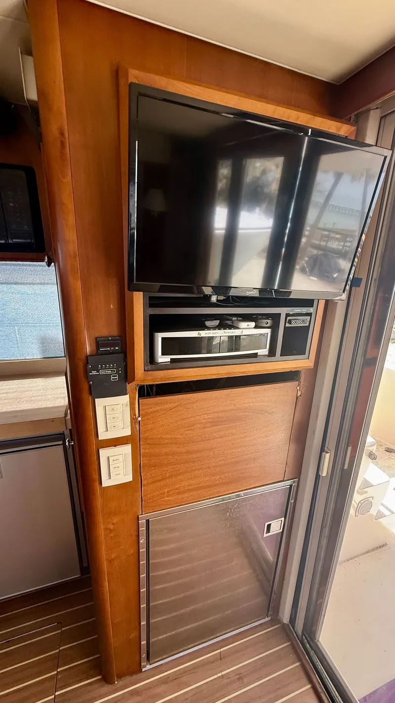 Slide: The Image of Interior of 2004 Mainship 400 Trawler with TV and wood paneling. - 15