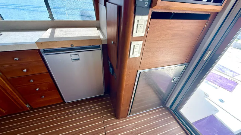 Slide: The Image of Interior of 2004 Mainship 400 Trawler with wood flooring and refrigerator. - 16