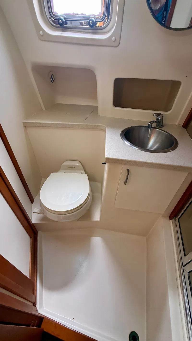 Slide: The Image of Bathroom in 2004 Mainship 400 Trawler with toilet and sink. - 23