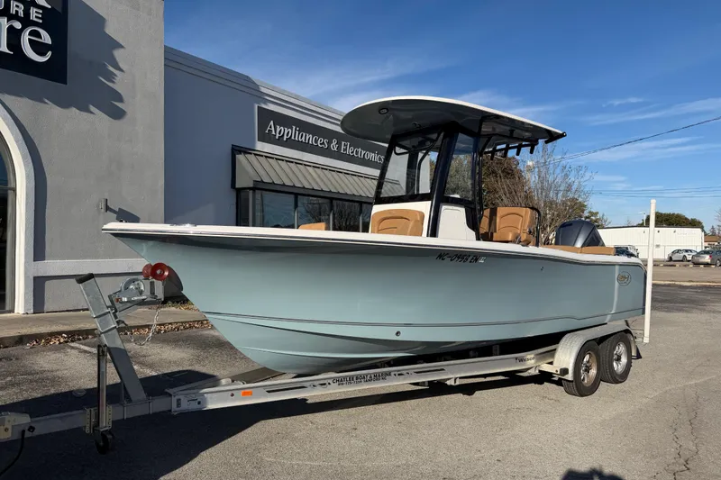 The Image of 2020 Sea Hunt Ultra 235 SE boat on trailer, parked outside appliance store. - 1