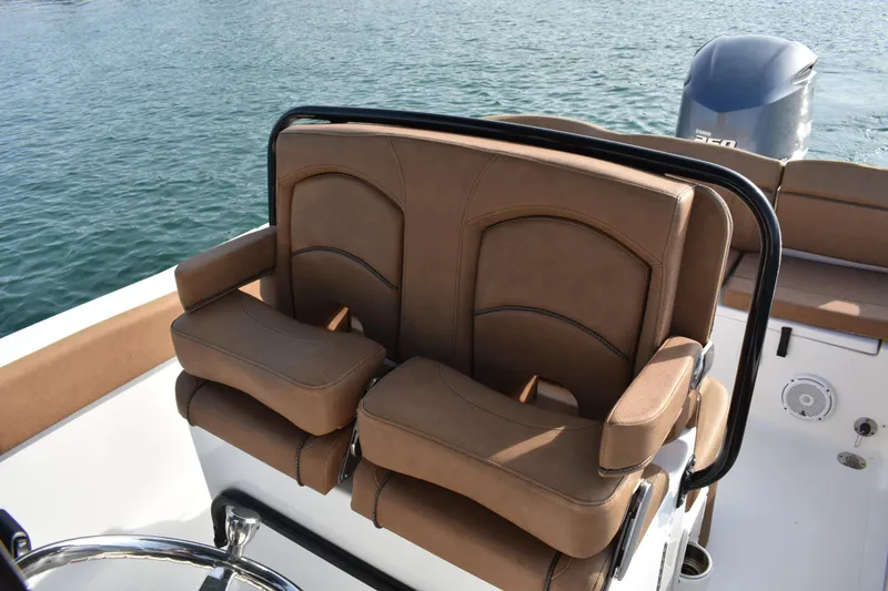 Slide: The Image of 2020 Sea Hunt Ultra 235 SE boat with brown cushioned seating and steering wheel. - 17