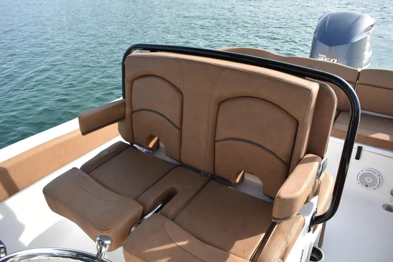 Slide: The Image of 2020 Sea Hunt Ultra 235 SE boat seating with brown upholstery and black railing. - 18