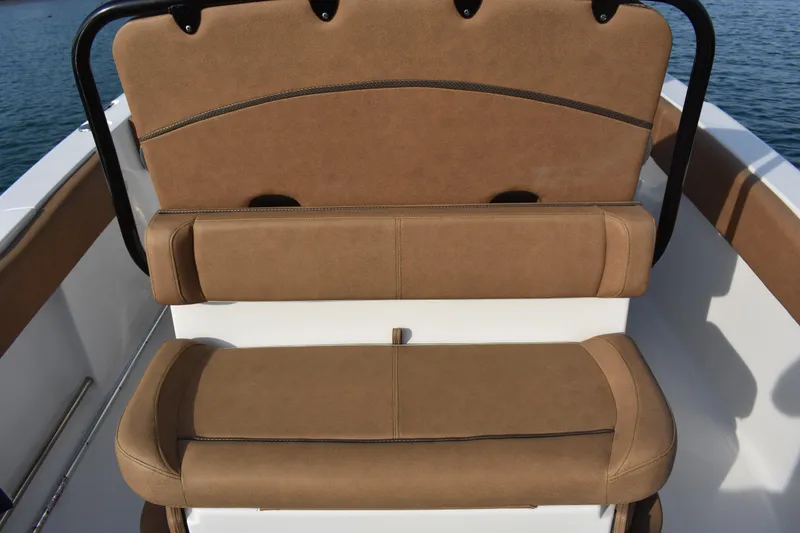 Slide: The Image of 2020 Sea Hunt Ultra 235 SE boat seating with brown upholstery on a sunny day. - 22
