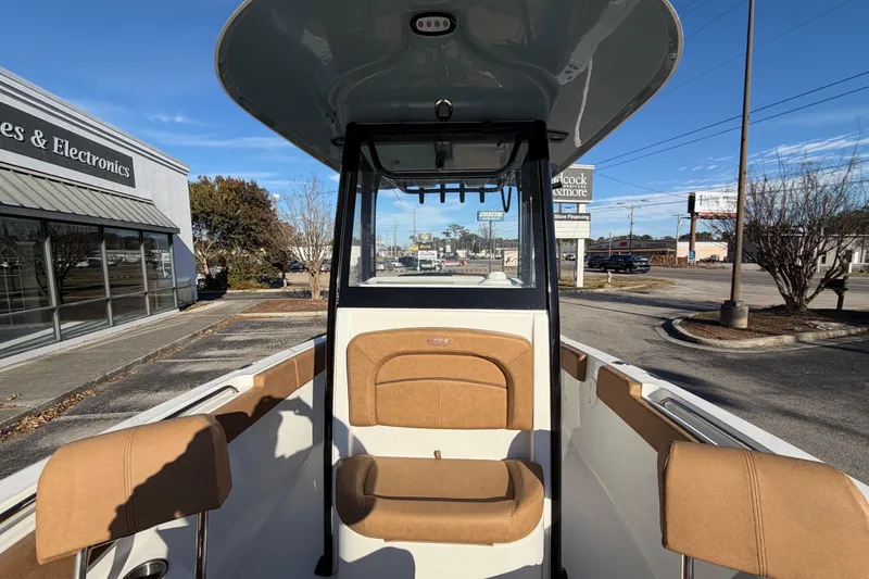Slide: The Image of 2020 Sea Hunt Ultra 235 SE boat cruising on calm waters near a marina. - 5