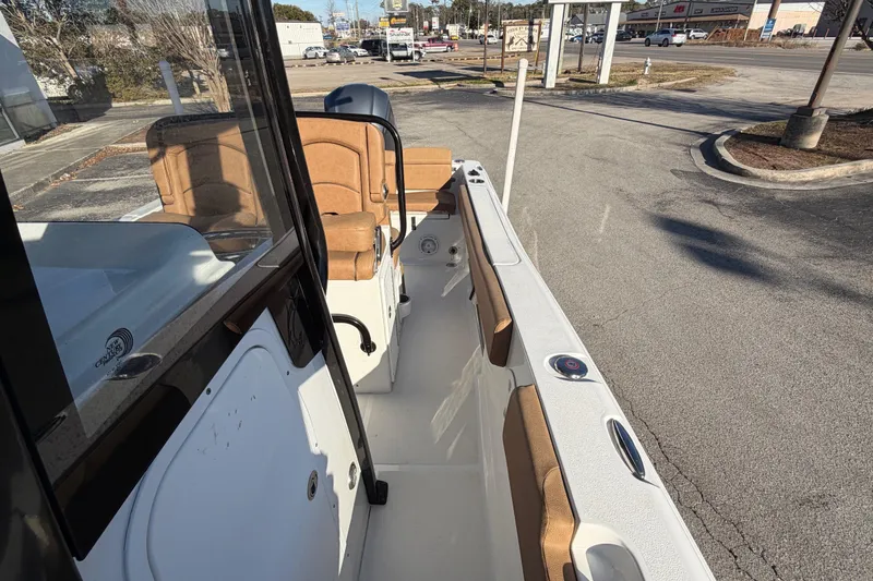 Slide: The Image of 2020 Sea Hunt Ultra 235 SE boat cruising near a dock with scenic background. - 7