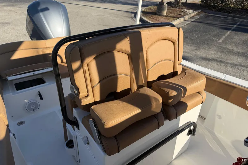 Slide: The Image of 2020 Sea Hunt Ultra 235 SE boat interior with cushioned seating on calm water. - 9