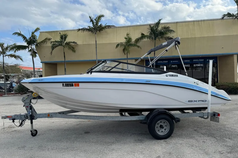 The Image of 2025 Yamaha Boats SX190 on trailer, parked outdoors near palm trees. - 0