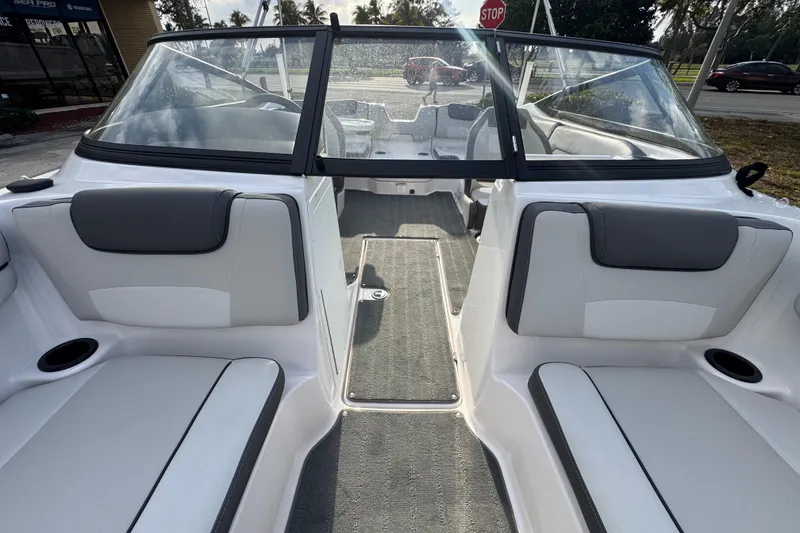 Slide: The Image of 2025 Yamaha Boats SX190 interior with gray and white seating, cup holders, and windshield. - 12