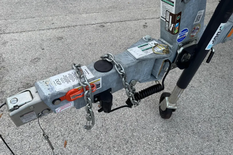 Slide: The Image of Trailer hitch of 2025 Yamaha Boats SX190 with safety chains and labels. - 15