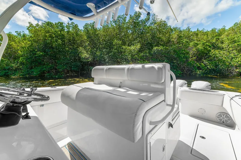 Slide: The Image of 2017 SeaHunter 35 Tournament boat interior with white seating, lush greenery in the background. - 7