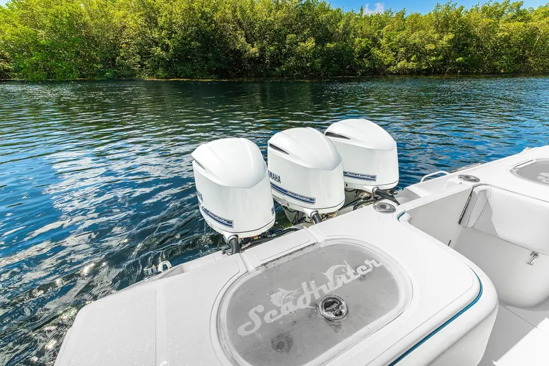 Slide: The Image of 2017 SeaHunter 35 Tournament boat with triple Yamaha outboard engines on a serene waterway. - 9