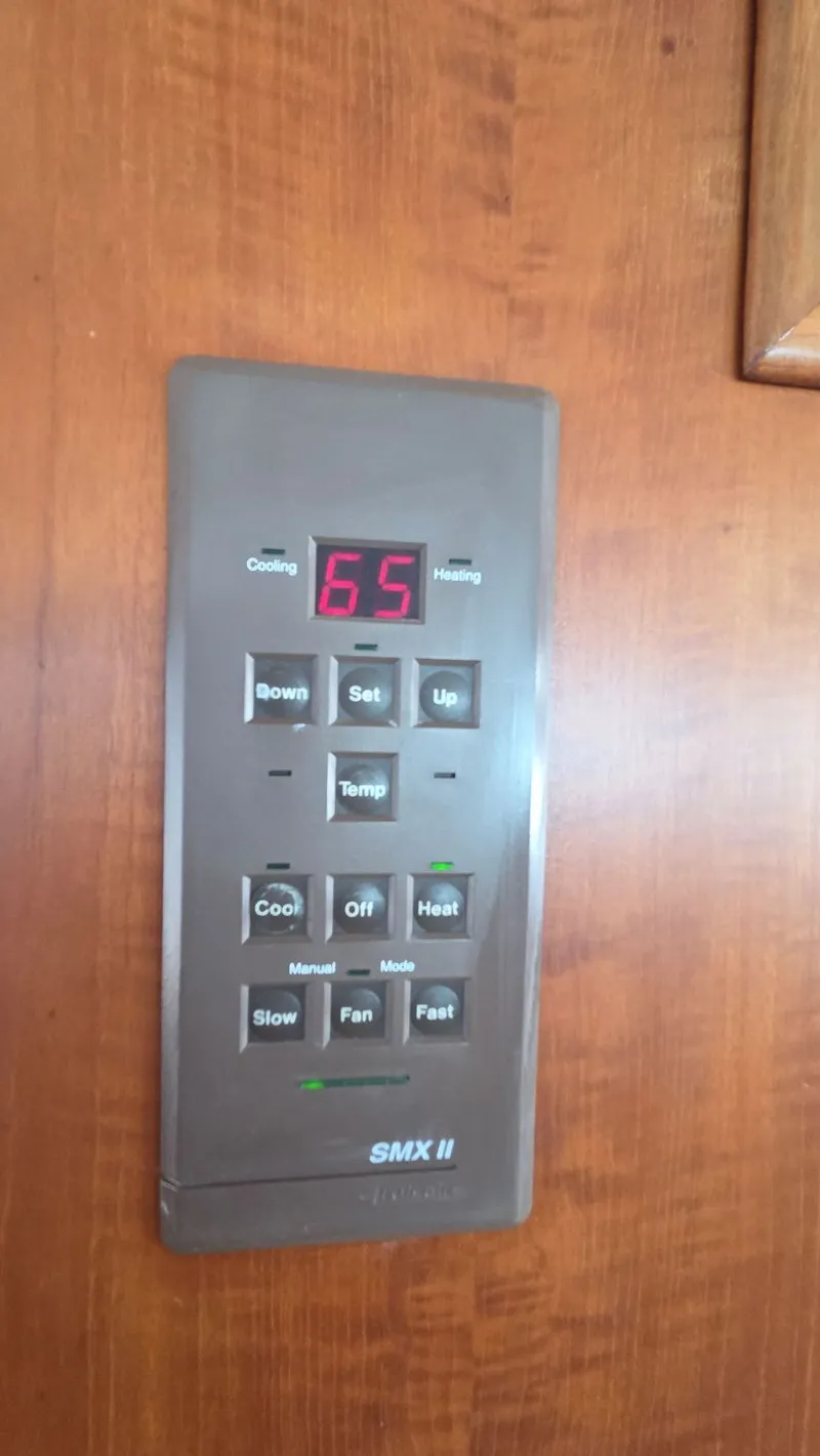 Slide: The Image of Thermostat in 1987 DeFever 48 Tri Cabin, displaying 65 degrees. - 43
