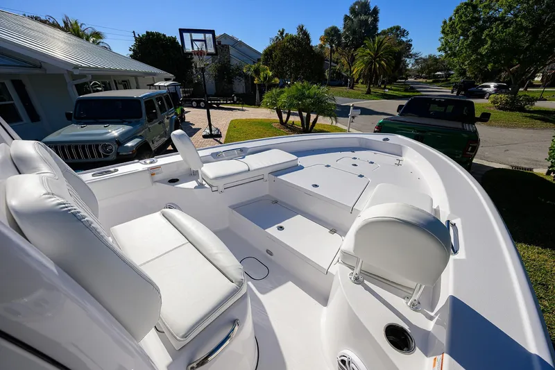 Slide: The Image of 2023 Sportsman Masters 267 Bay Boat with white seating, parked in a residential driveway. - 11